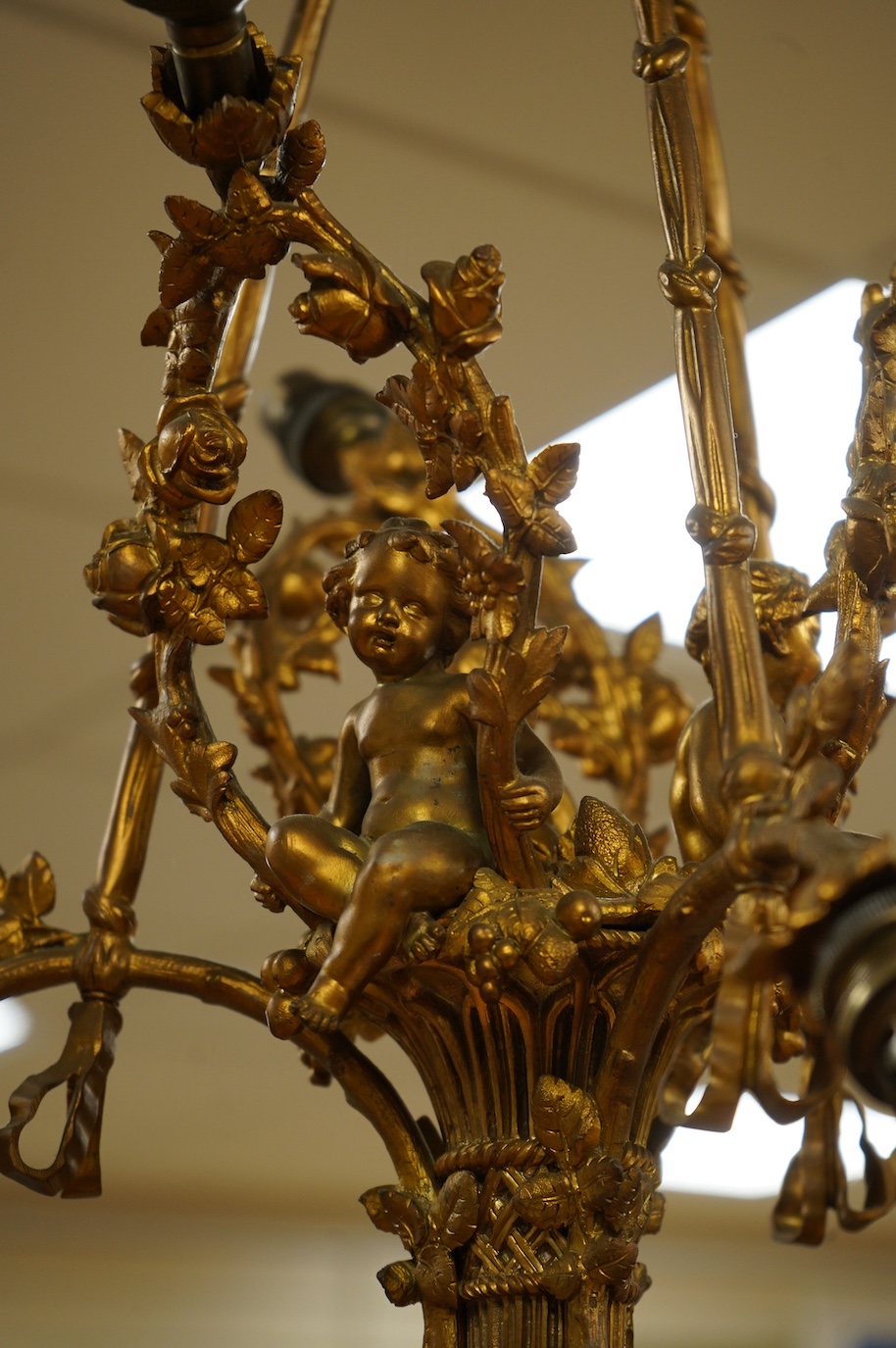 A gilt metal chandelier in the form of a cherub in a basket, 65cm high. Condition - fair, untested